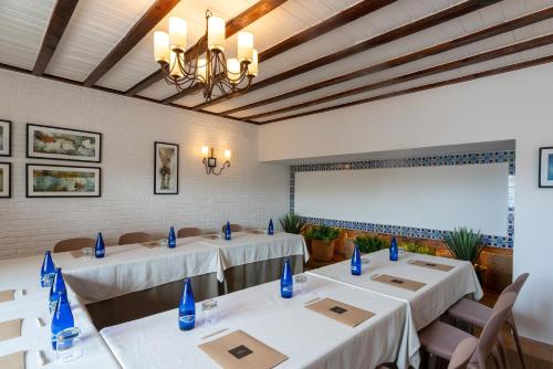 a room with tables and chairs and a projection screen at Parador de Mazagón in Mazagón