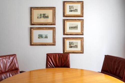 a conference room with a table and four framed pictures on the wall at Parador de Mazagón in Mazagón