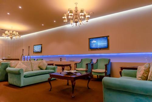 a living room with couches and a table and a tv at Howard Johnson Plaza by Wyndham Buenos Aires Florida Street in Buenos Aires