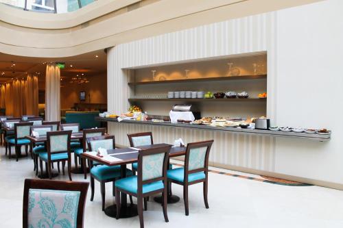 a restaurant with tables and chairs and a buffet at Howard Johnson Plaza by Wyndham Buenos Aires Florida Street in Buenos Aires