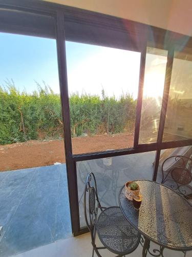 eine Terrasse mit einem Tisch, Stühlen und einem Fenster in der Unterkunft קסם היסוד in Yesud HaMa'ala