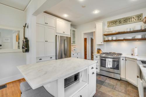 a kitchen with white cabinets and a counter top at Charming Louisville Retreat with Patio and Fireplace! in Louisville