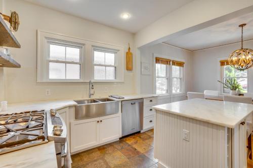 a kitchen with white cabinets and a sink at Charming Louisville Retreat with Patio and Fireplace! in Louisville