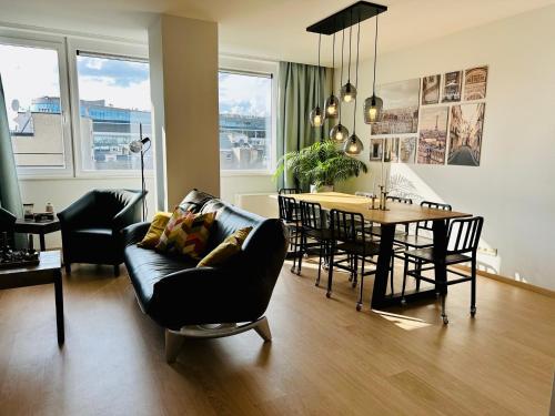 a living room with a couch and a table with chairs at Urbanstay Suites - Grand Place 2 Bd Apartment in Brussels