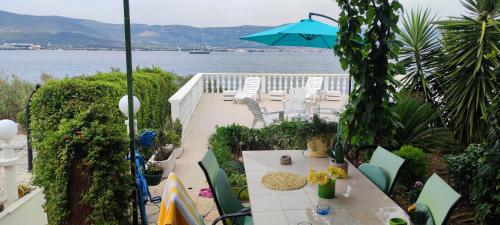 een patio met een tafel en stoelen en een parasol bij Villa Fjaba - by the sea - with the big terraces & great sea view in Trogir
