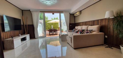 a living room with a couch and a television at Adosado Marbella Paraíso in Marbella