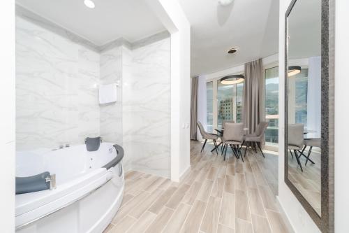 a bathroom with a tub and a table with chairs at Skyline Vista in Bečići