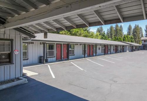 an empty parking lot in front of a building at Charm Motel & Suites in Burney
