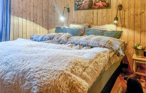 - un grand lit dans une chambre dotée de murs en bois dans l'établissement Nice Home In Sjusjen With Sauna, à Sjusjøen