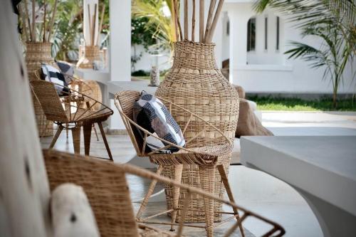 a group of wicker chairs and vases on a patio at Antares Villa in Kiwengwa