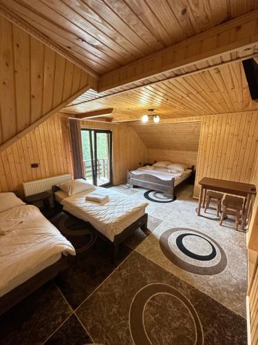 a room with two beds in a wooden cabin at Приватна садиба SHAFRAN in Yablunytsya