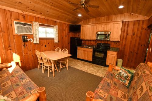 uma cozinha com uma mesa e cadeiras num camarote em Lake George Diamond Cove Cottages, Cabins, & Hotel em Lake George