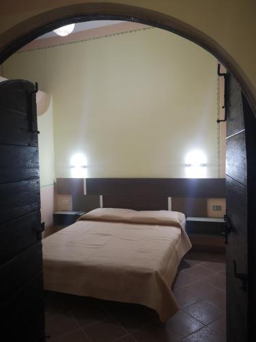 Un dormitorio con una cama y dos luces en la pared. en Ai Campanili, en San Severo