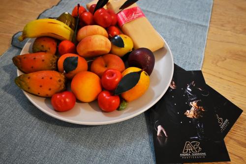 a bowl of fruit on a plate next to a bag at Mimosa e Agave Blu in Scicli