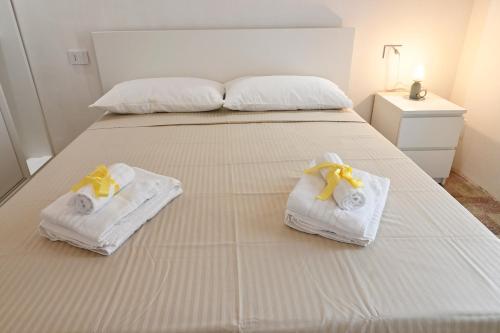 a bedroom with a bed with towels on it at Mimosa e Agave Blu in Scicli