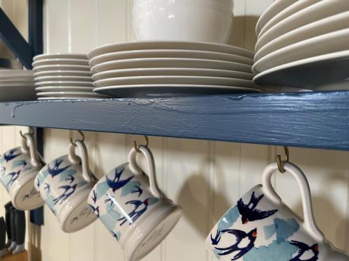 a blue shelf with plates and utensils on it at The Nest in Kingsbridge