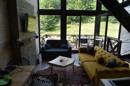 sala de estar con sofá y mesa en Vila Prive - Bungalows Kopaonik en Kopaonik