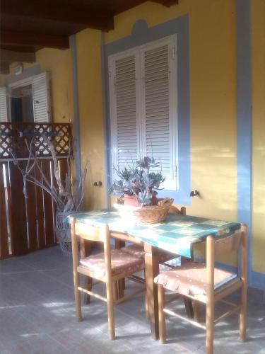 a table and two chairs with a plant on it at Appartamenti Claudia Rio in Rio Marina