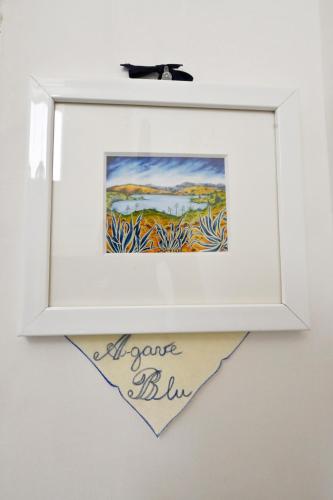 a picture frame hanging on a wall with a painting at Mimosa e Agave Blu in Scicli