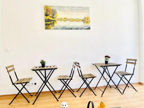 tavolo e sedie in una stanza con un dipinto sul muro di SwissLisbon Guest House a Lisbona