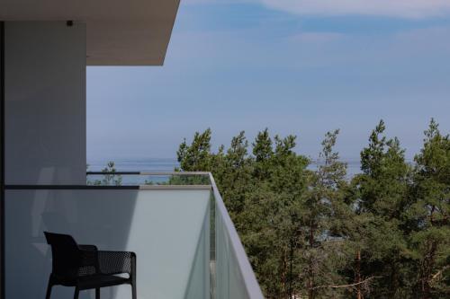 uma cadeira numa varanda com vista para o oceano em Royal Waves Resort & SPA - Apartment with Parking by Renters em Międzyzdroje