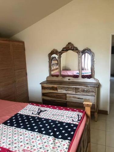 a bedroom with a bed and a dresser with a mirror at Leila VIllage Plus in Mendes