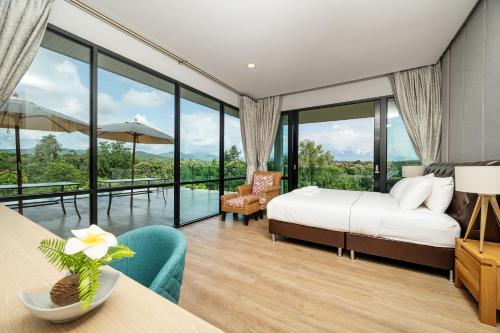 a bedroom with a king sized bed and a balcony at Empreo Residence Pool Villa (เอมพรีโอ พูล วิลลา) in Ban Thung Satong