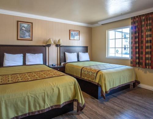 Burney的住宿－Charm Motel & Suites，酒店客房设有两张床和窗户。