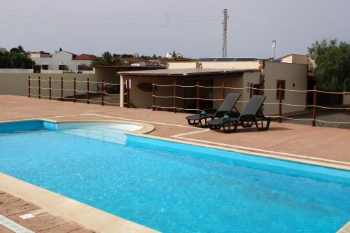 a swimming pool with two chairs next to a house at Eco Terra by Sea You There Fuerteventura in Puerto del Rosario