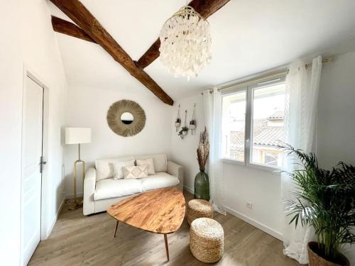 - un salon avec un canapé et une table dans l'établissement Ravissant appartement au cœur d’Aix, à Aix-en-Provence