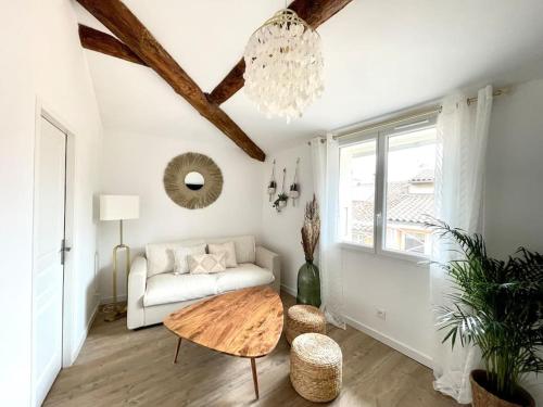 un salon avec un canapé et une table dans l'établissement Ravissant appartement au cœur d’Aix, à Aix-en-Provence