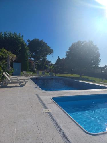 a swimming pool with blue water in a yard at Quintinha dos Amores in Vila Verde