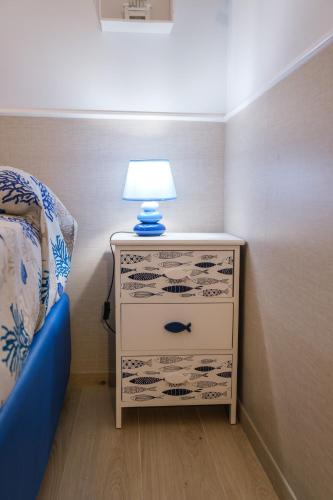 a bedroom with a dresser with a lamp on it at Appartamenti Vale Mare 2 in Chioggia