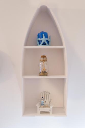 a white book shelf with a figurine of a window at Appartamenti Vale Mare 2 in Chioggia