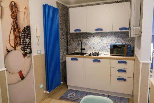 a small kitchen with white cabinets and a sink at Appartamenti Vale Mare 2 in Chioggia