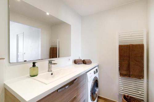 uma casa de banho com um lavatório e uma máquina de lavar roupa em Appartements climatisés - Vieil Antibes em Antibes