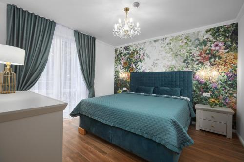 a bedroom with a blue bed and a painting on the wall at Rustyfox in Remetské Hámre