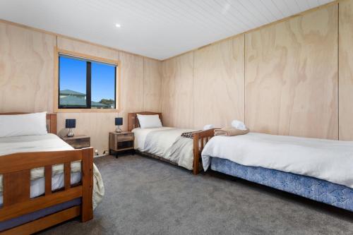 a bedroom with two beds and a window at Beach Bach on Boulevard in Opotiki