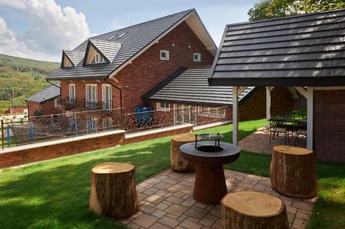 a patio with a table and stools in front of a house at Rustyfox in Remetské Hámre