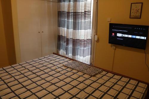 a bedroom with a bed and a window and a television at Apartment of Zeus/Leptokarya in Leptokaria