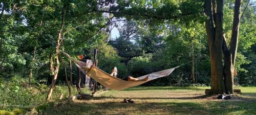 a woman is lying in a hammock in a tree at Einfachlosmachen-Zeltpunkt in Aulosen