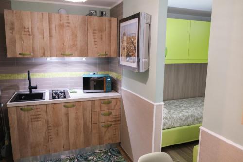 a small kitchen with wooden cabinets and a microwave at Appartamenti Vale Mare 2 in Chioggia