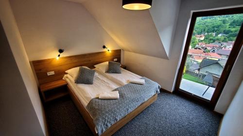a bedroom with a bed and a large window at Willa Kania in Szczawnica