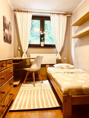 - une chambre avec un lit, un bureau et une fenêtre dans l'établissement InOut Olsztyn, à Olsztyn