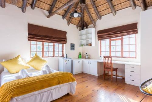 a bedroom with a large bed and a kitchen at Mead, Pinelands in Cape Town
