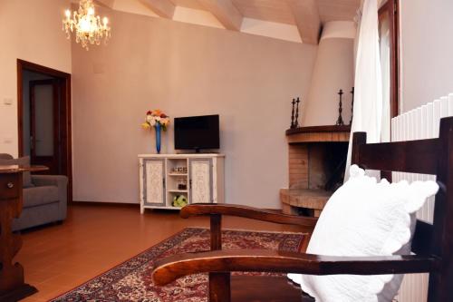 een woonkamer met een stoel en een open haard bij La Casa del Borgo Antico in Spoleto