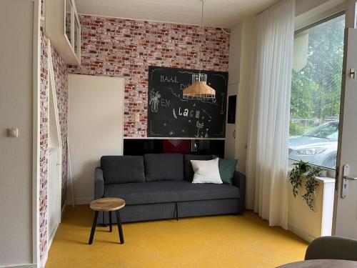 uma sala de estar com um sofá e uma parede de tijolos em studio 4 em Workum