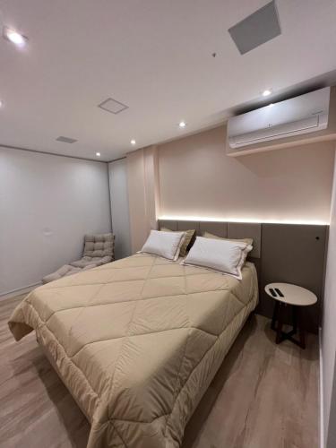 a bedroom with a large bed and a table at Apartamento de luxo em Jardins, Oscar Freire in Sao Paulo
