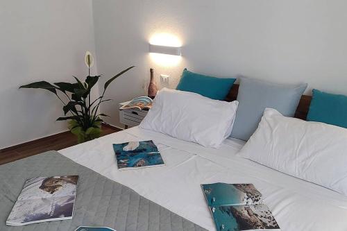 アルゲーロにあるcasa vacanze Gente di mareの絵と枕が置かれた白いベッド