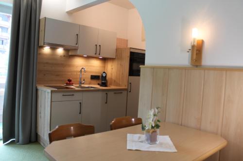 a kitchen with a table with chairs and a sink at Apartment Panorama in Wagrain